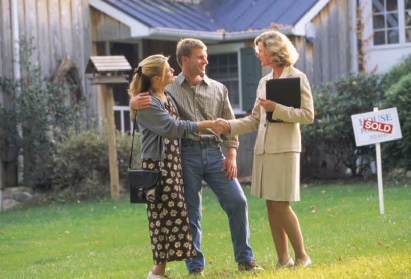 Couple in Front Yard of home with Real Estate Agent